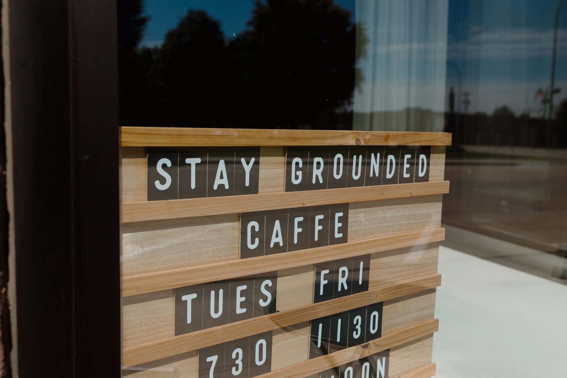 Stay Grounded Caffe letter board in the window of the coffee shop.